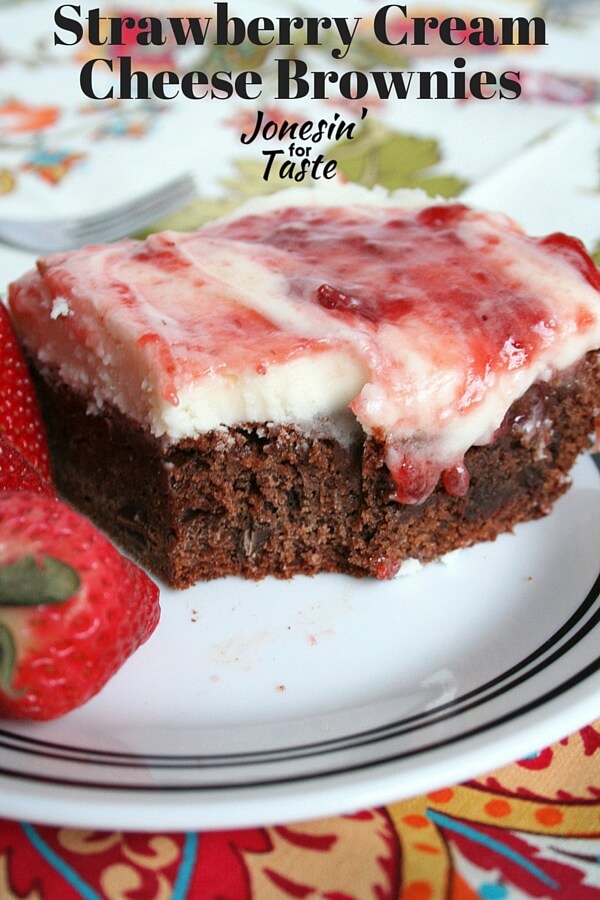 Brownie topped with cream cheese frosting and strawberry jam