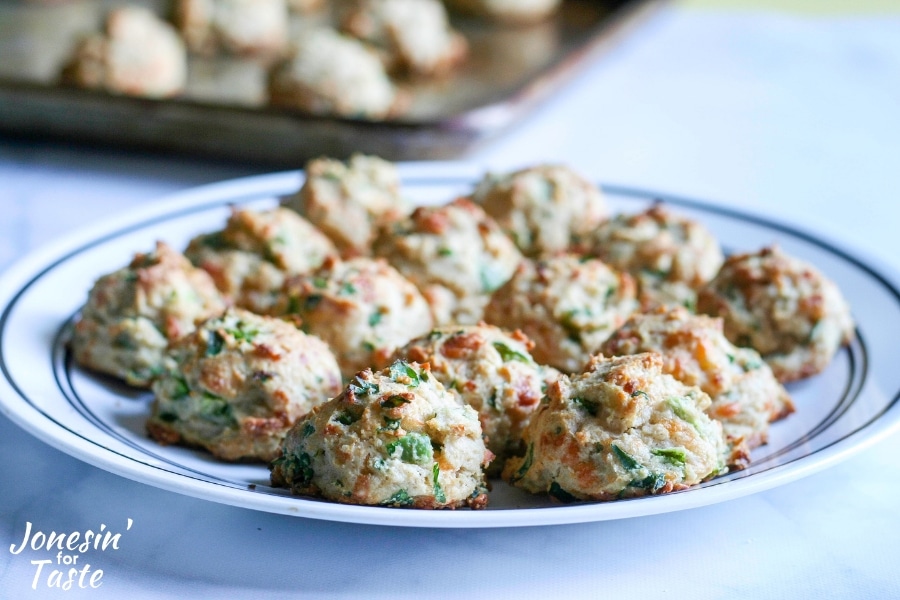 A closeup of a plate full of cheesy garlic jalapeno drop biscuits