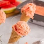 watermelon in ice cream cones. The cones sit in glass cups.