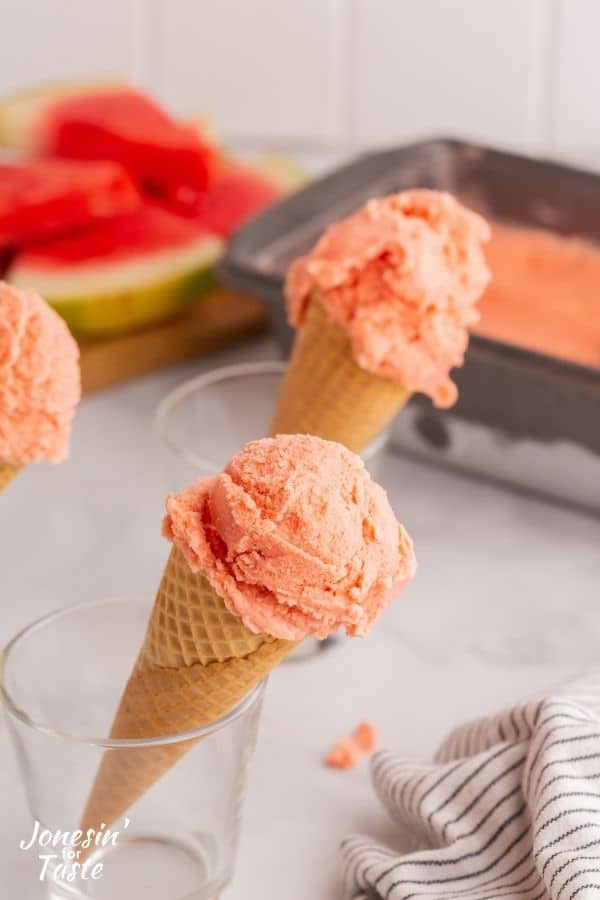 watermelon in ice cream cones. The cones sit in glass cups.