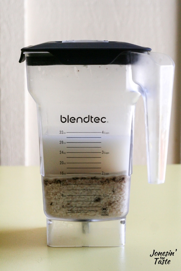 A blender with water, rice and cinnamon sticks in it