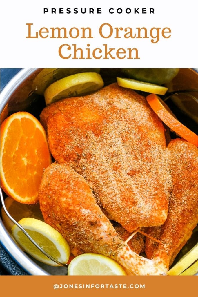 a whole chicken coated in a spice rub sits in a pressure cooker pot surrounded by orange and lemon slices