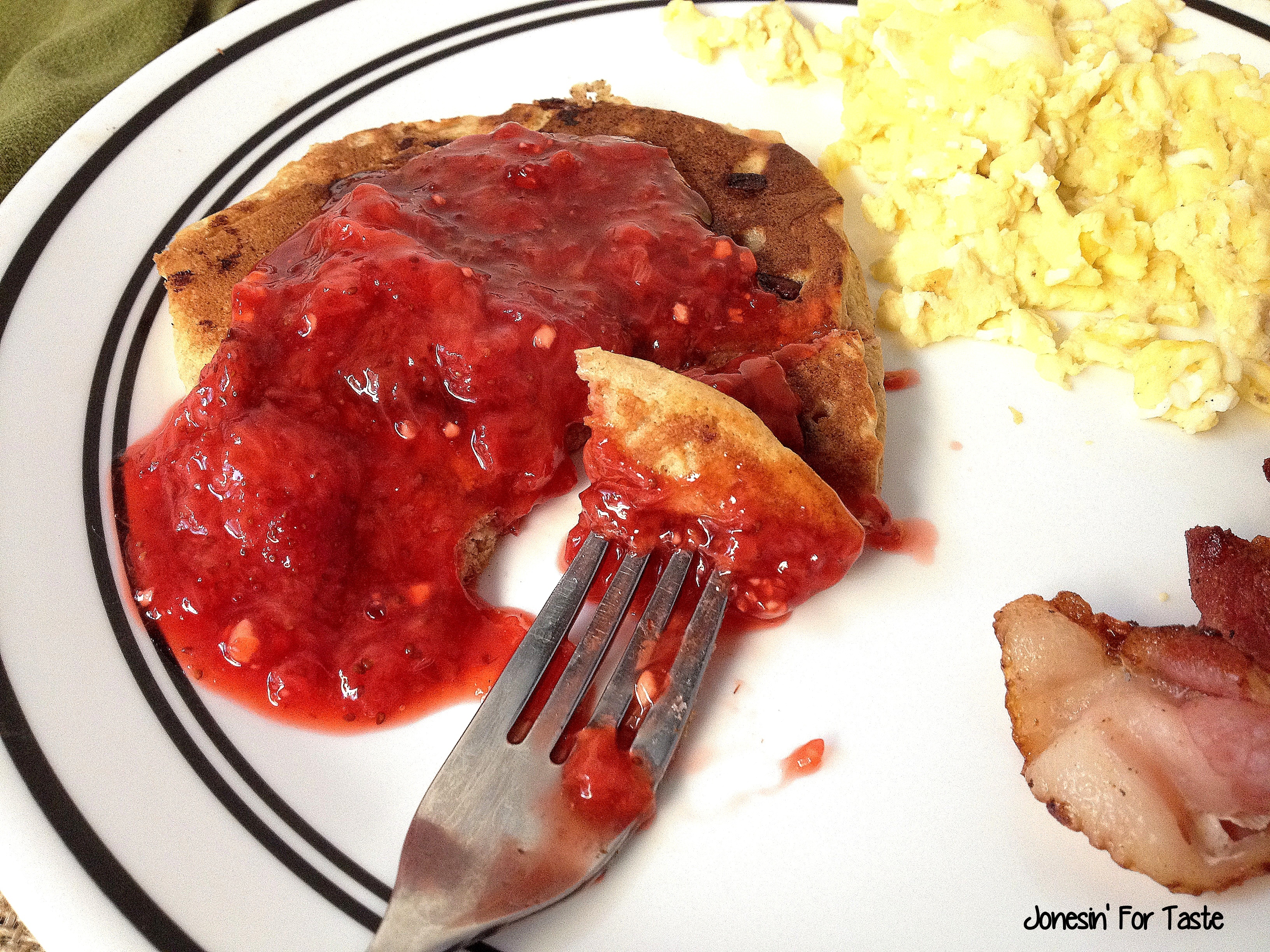 Strawberry sauce over pancakes on a white plate