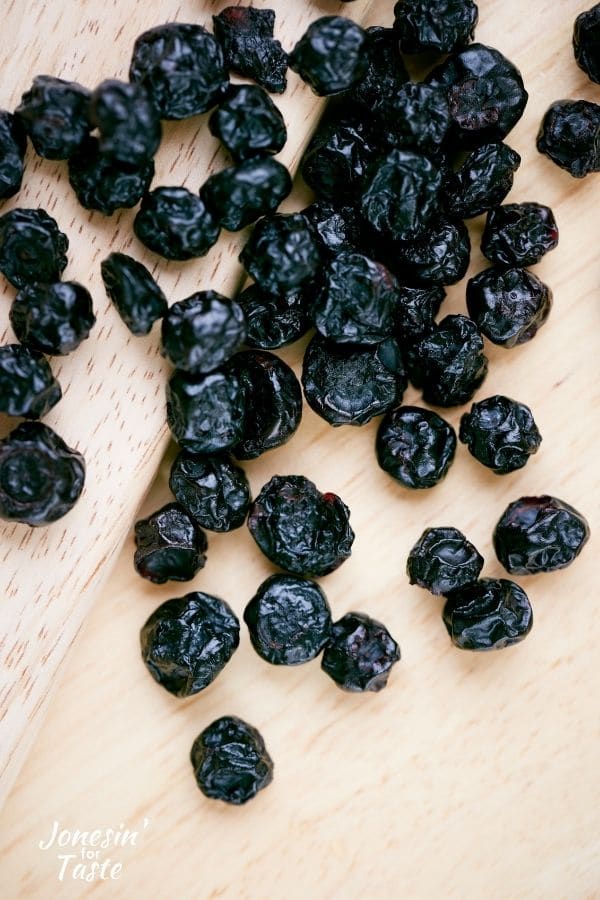 dried blueberries on a light wood backdrop
