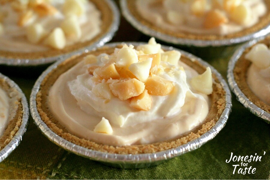 A mini no bake pumpkin cheesecake topped with whipped cream and chopped macadamia nuts.