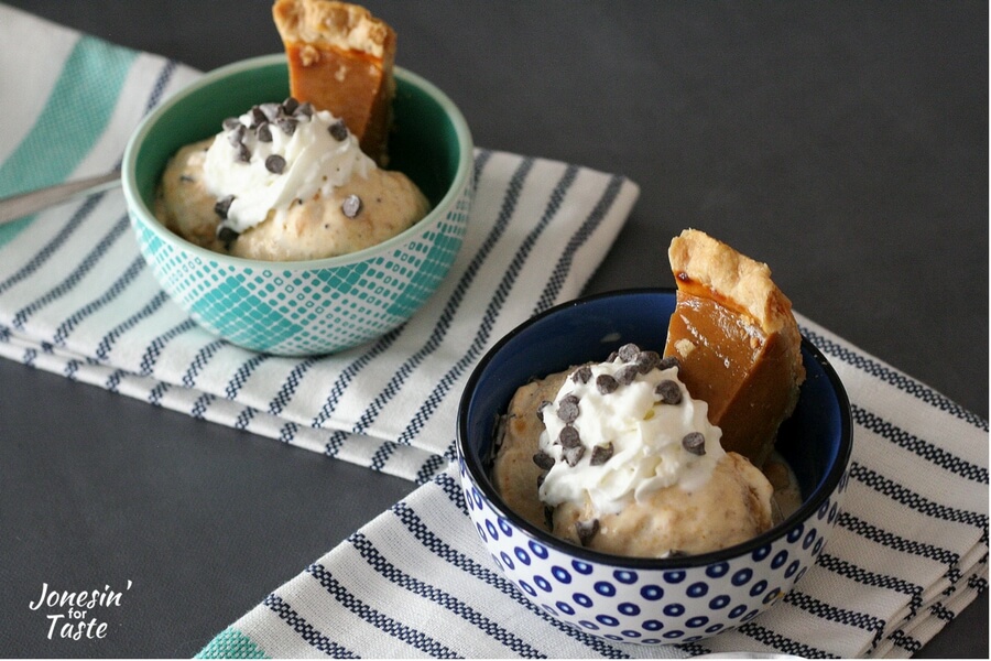 Two blue bowls filled with pumpkin pie ice cream sundaes with an extra sliver of pumpkin pie to top