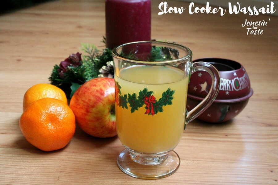 A glass Christmas mug of Slow Cooker Wassail in front of Christmas decor