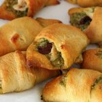 A pile of chicken croissants with pesto and sun dried tomato