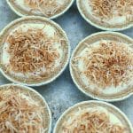 A group of mini no bake coconut cheesecakes
