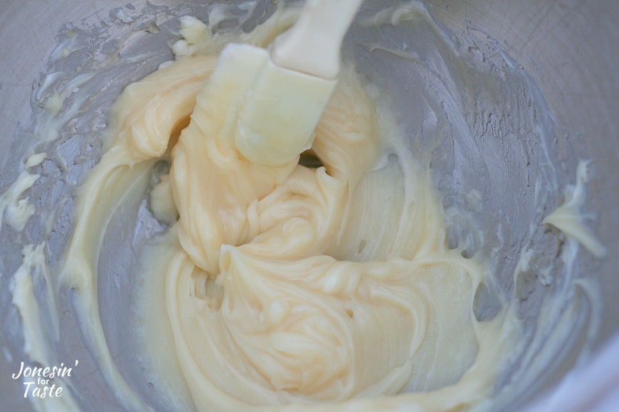 butter and honey mixed together in a large bowl with a spatula.