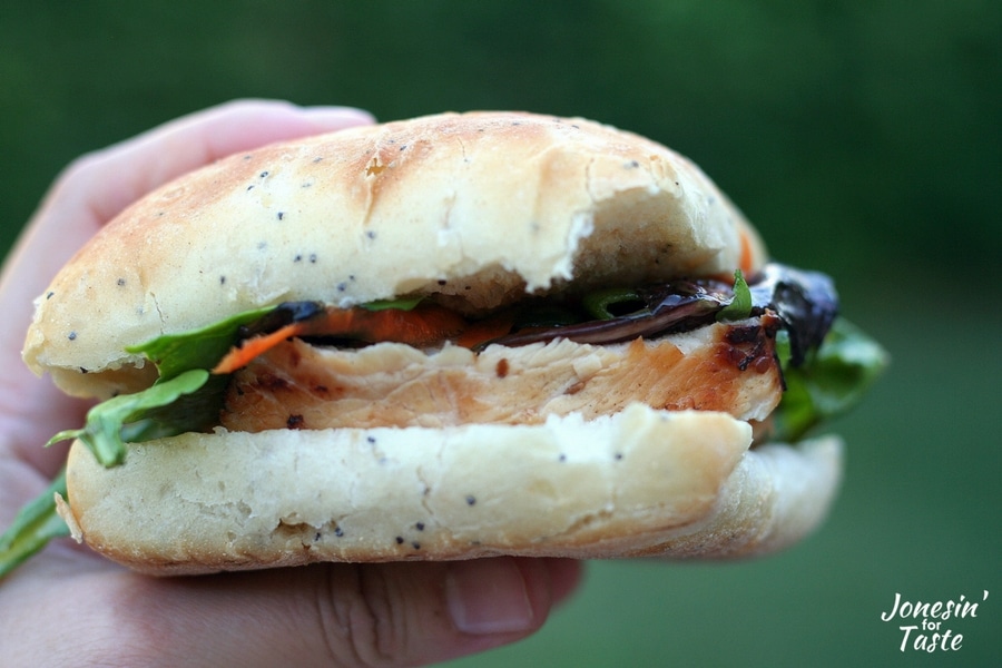 a hand holding an easy sesame grilled chicken sandwich