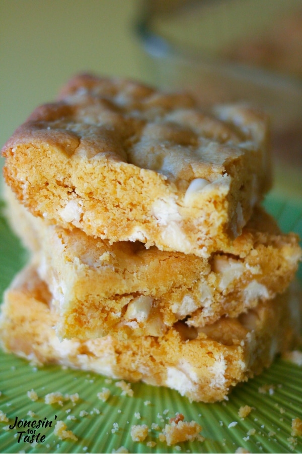A tower of white chocolate peanut butter cookie bars on a green plate.