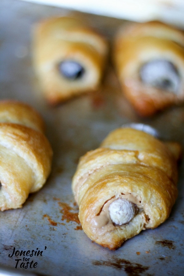 Baked Easy Peanut Butter and Banana croissants on a well used baking sheet.