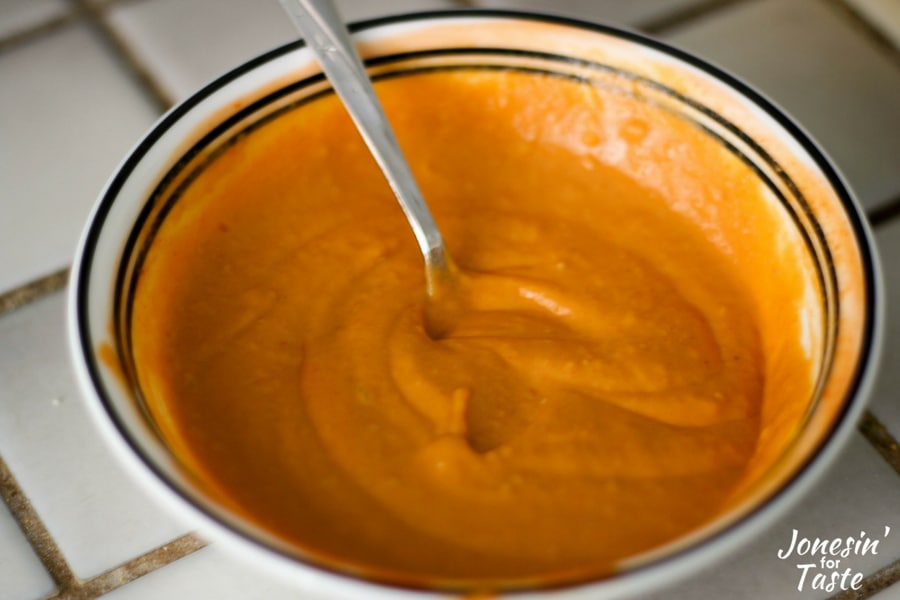 a bowl of the buffalo hummus sauce for the lighter grilled buffalo chicken