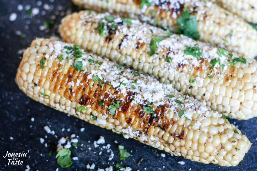 Grilled cumin corn sprinkled with cotija cheese and cilantro with beautiful char marks