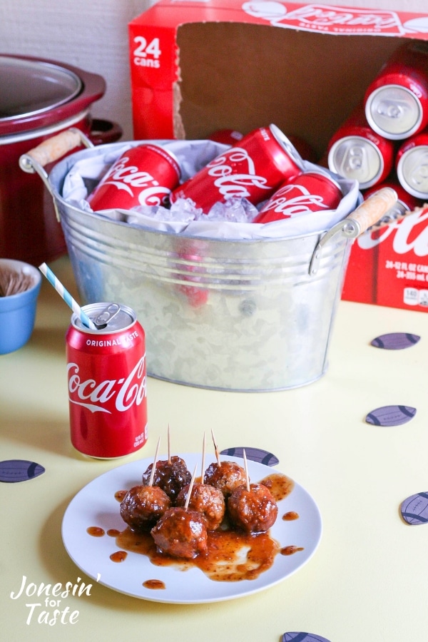 A plate of Coca Cola BBQ Meatballs next to a bucket of iced Coca-Colas