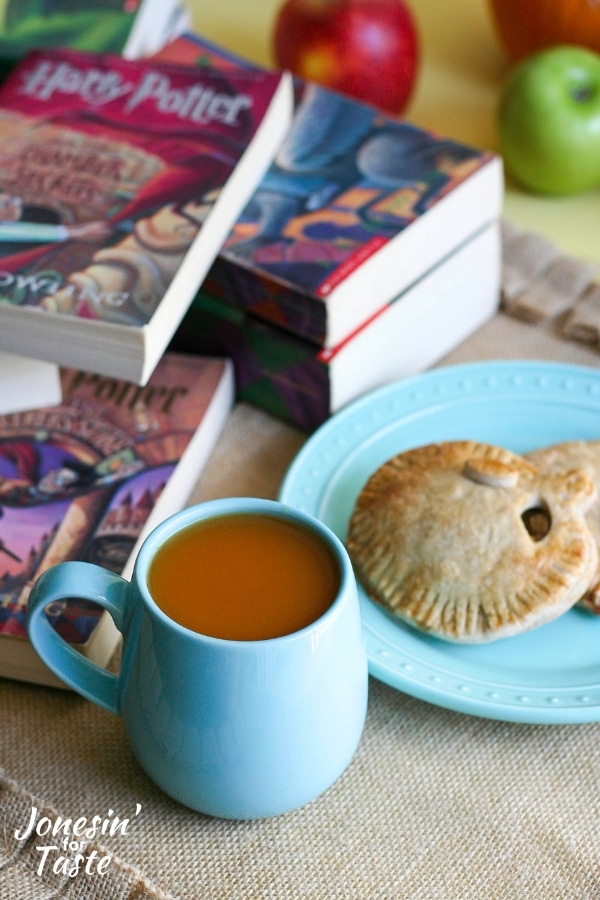 Pumpkin pasties, hot pumpkin cider, and Harry Potter books on a table.