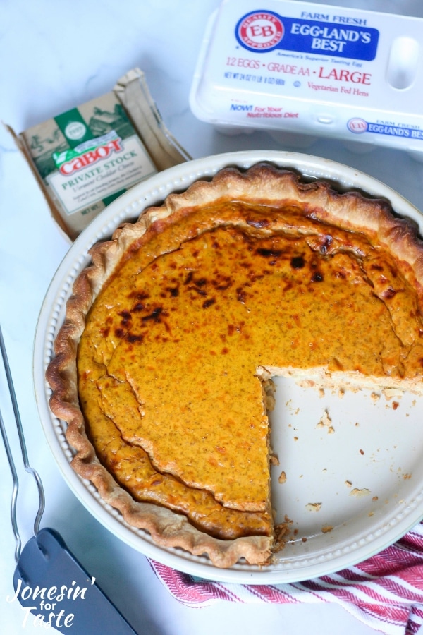 A pumpkin quiche with slices missing