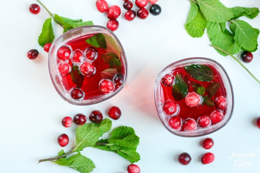 2 cups of festive cranberry holiday punch with floating mint and cranberries