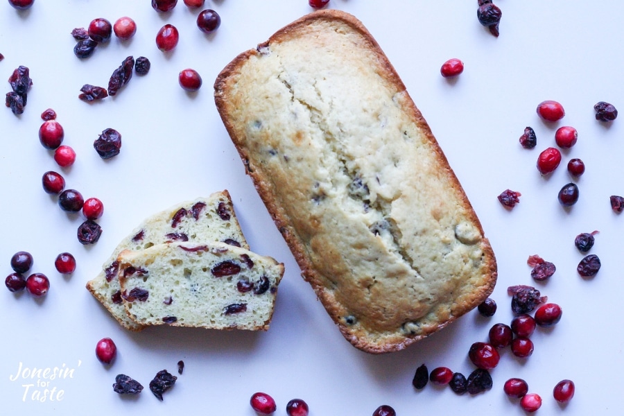 Cranberry eggnog bread surrounded by fresh and dried cranberries