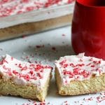 Iced Peppermint Cookie Bars next to a mug and pan