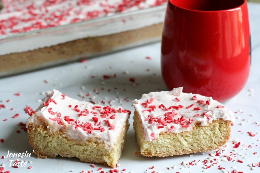 Iced Peppermint Cookie Bars next to a mug and pan