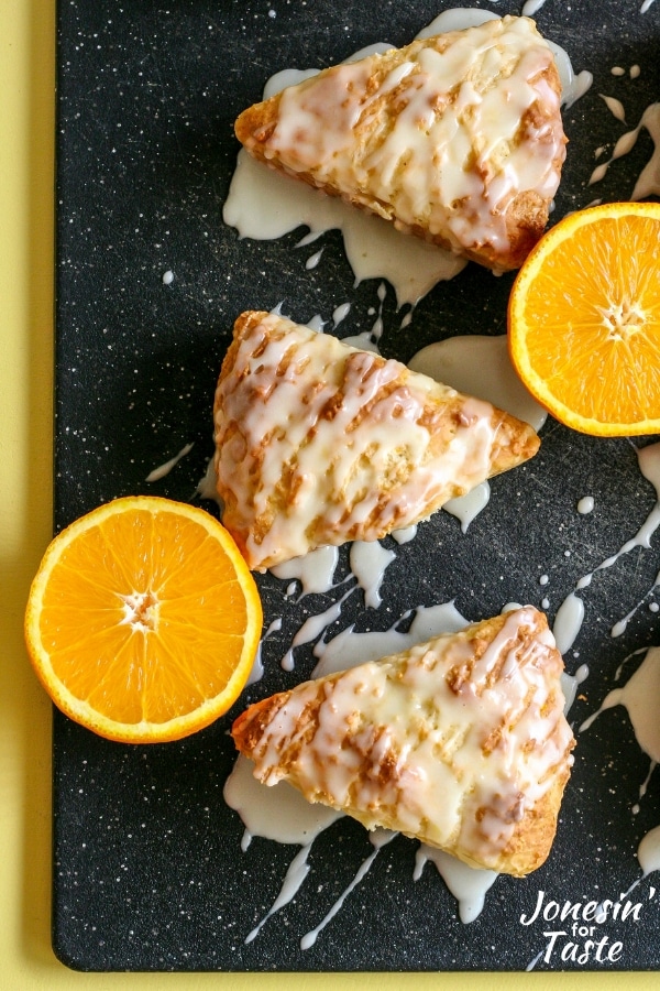 Scones on a cutting board next to halved oranges