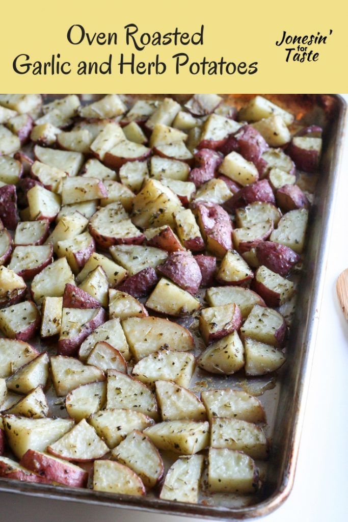 Cooked garlic and herb potatoes on a cookie sheet