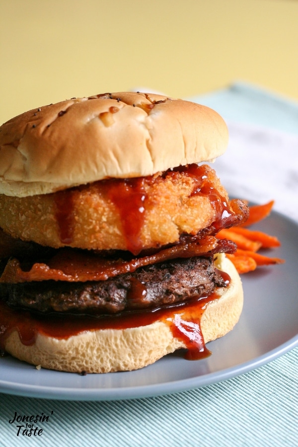 A burger with bbq sauce, bacon, and onion ring