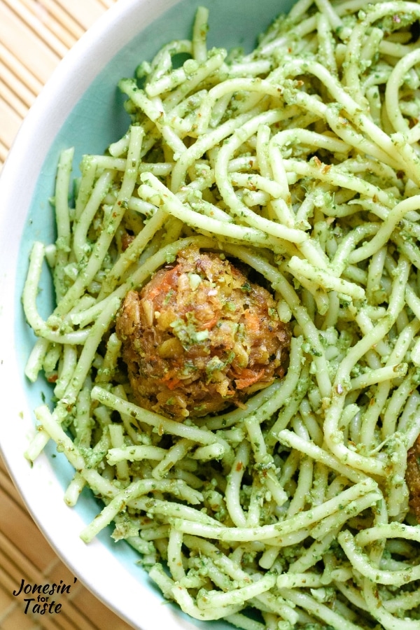 flecks of veggies in a meatball nestled in green pasta