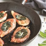 chicken saltimbocca in a black pan on a white counter