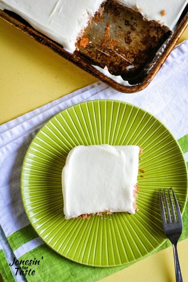 a green plate with cake next to the cookie sheet with a slice missing