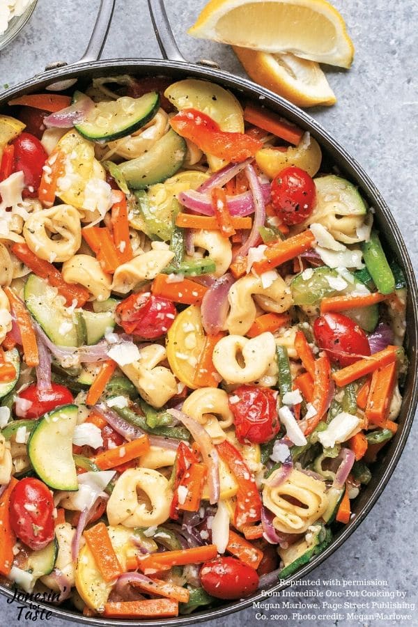 a large pan filled with tortellini and a rainbow of vegetables
