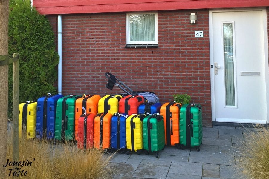 colorful suitcases lined up outside a house