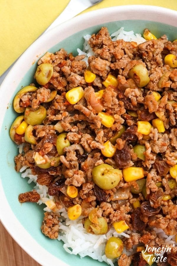 a close up of the picadillo with olives, corn, and raisins