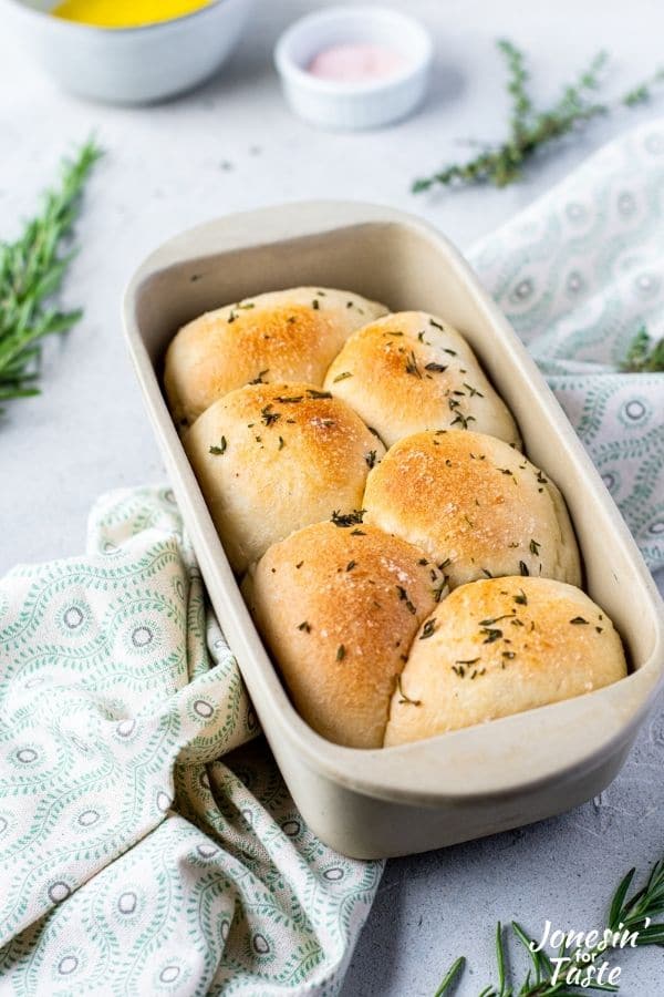 a loaf pan with rolls sprinkled with herbs