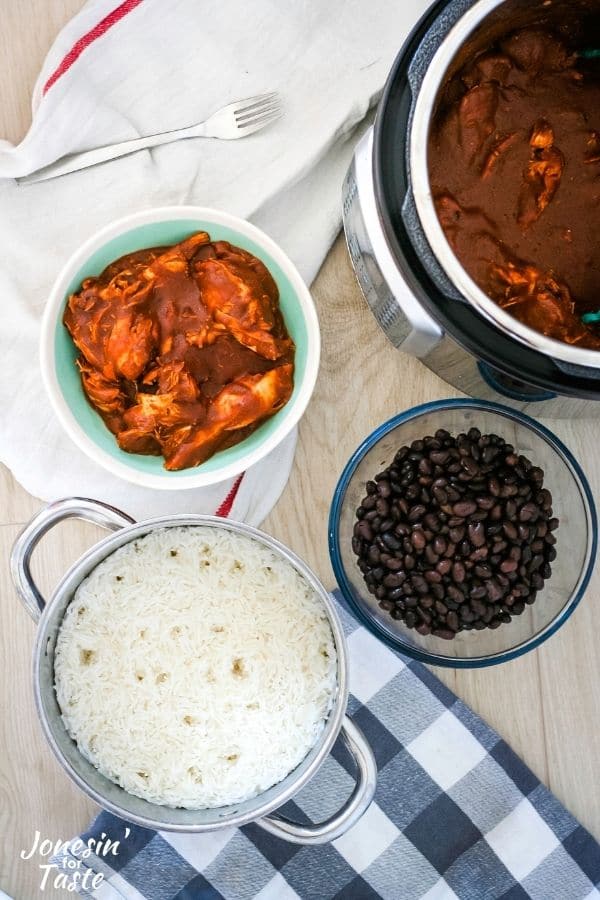 bowls of rice, beans, and mole chicken