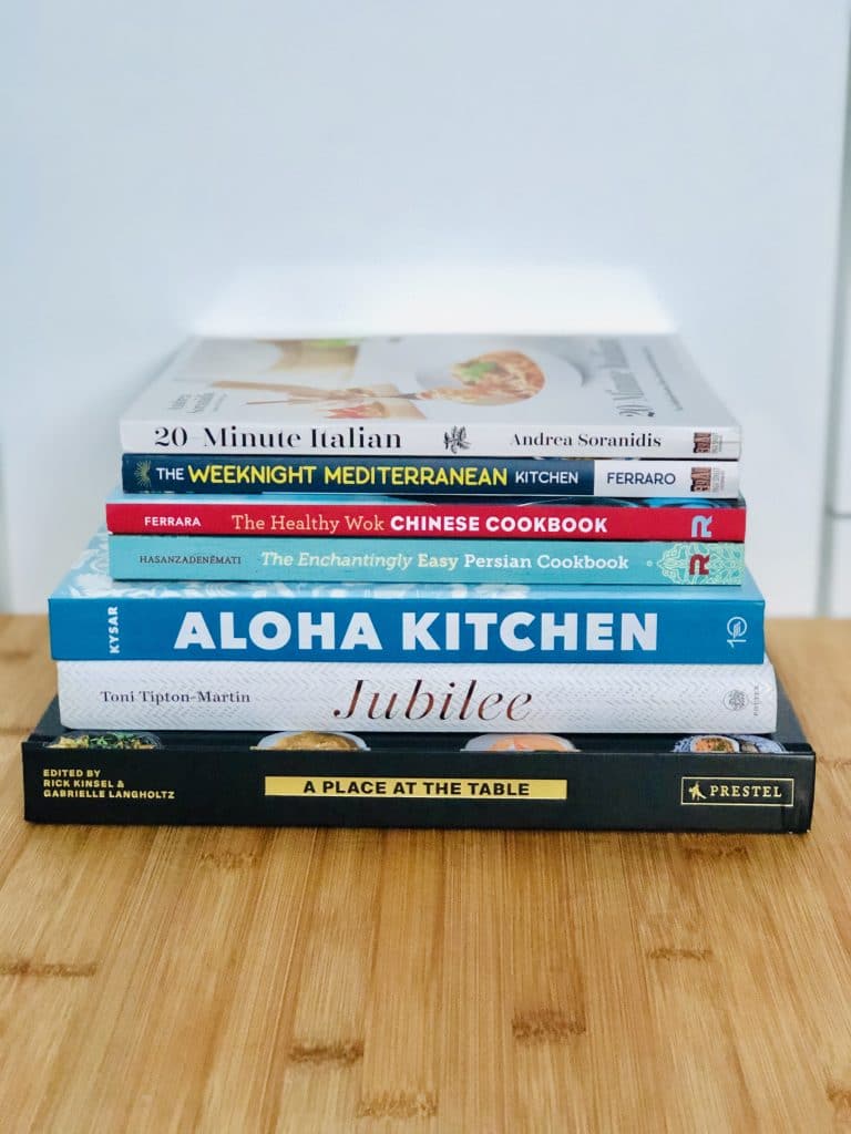 a picture of a colorful stack of cookbooks with text that says our family's favorite global cuisine cookbooks