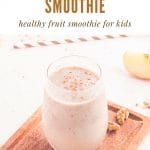 a text and photo collage. Text at the top says apple cinnamon smoothie, healthy fruit smoothie for kids. The photo below is of a glass of apple cinnamon smoothie on a wooden cutting board