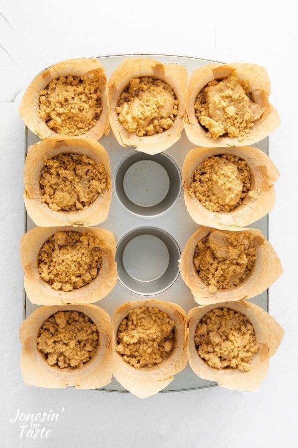 muffin batter in paper liners topped with crumble mix