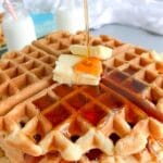 syrup being poured over the waffles
