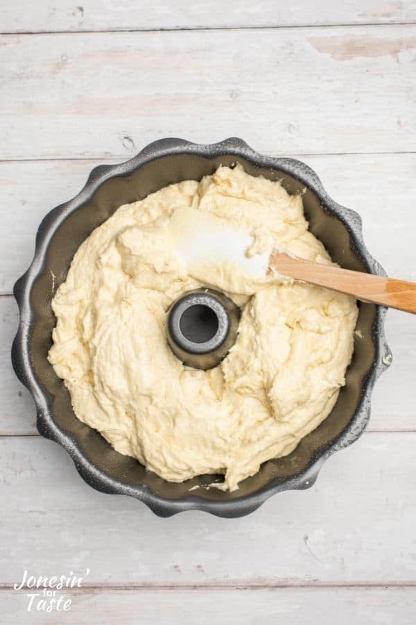cake batter being spread out in a Bundt pan with a spatula
