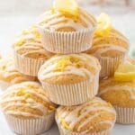 a pyramid of lemon muffins criss crossed with lemon glaze. Some are topped with a slice of lemon