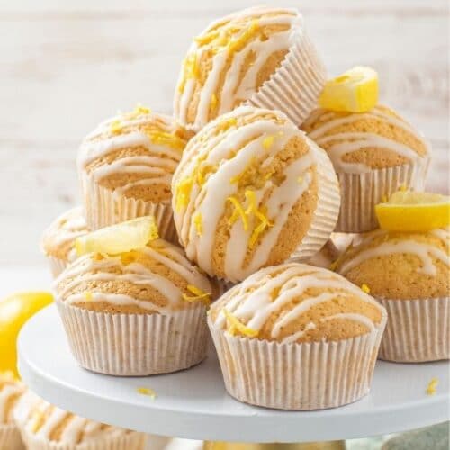 glazed lemon muffins stacked in a tumbling pile on a cake stand