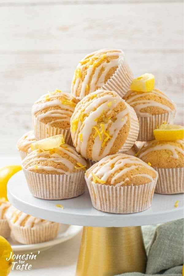 glazed lemon muffins stacked in a tumbling pile on a cake stand