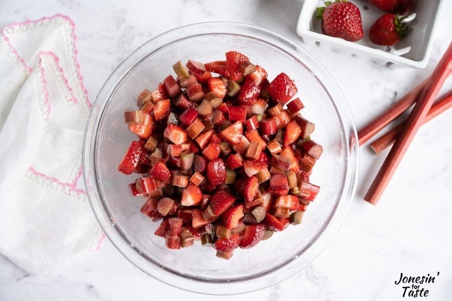 a bowl with chopped strawberries and rhubarb on a white background