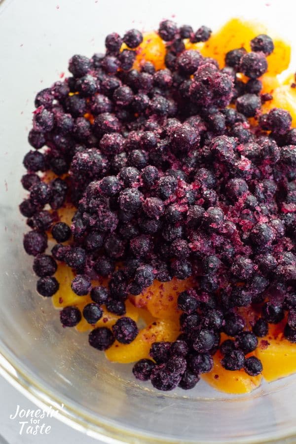 blueberries and peaches in a glass bowl